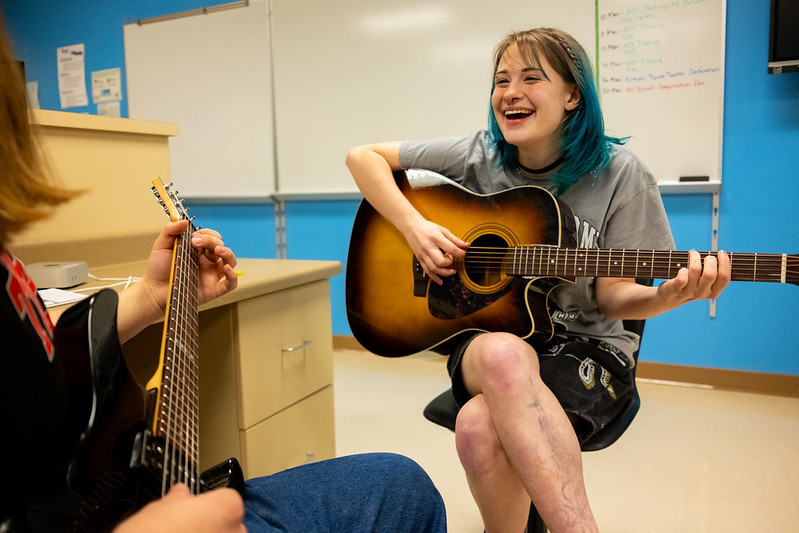 student playing guitar in class