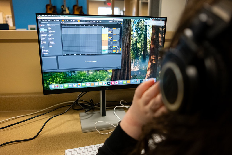 Student sitting at a computer doing music editing