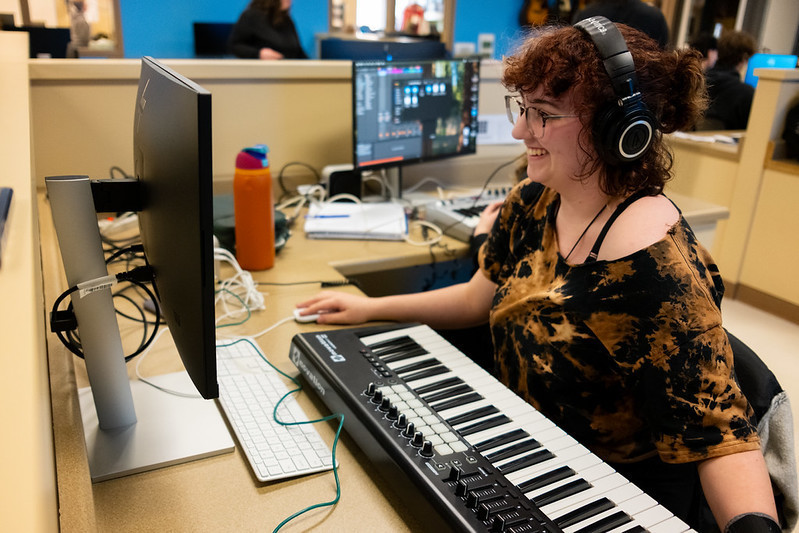 Student sitting at a computer doing music editing