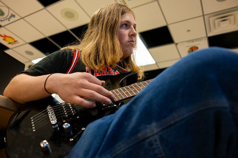 Student playing a guitar in class