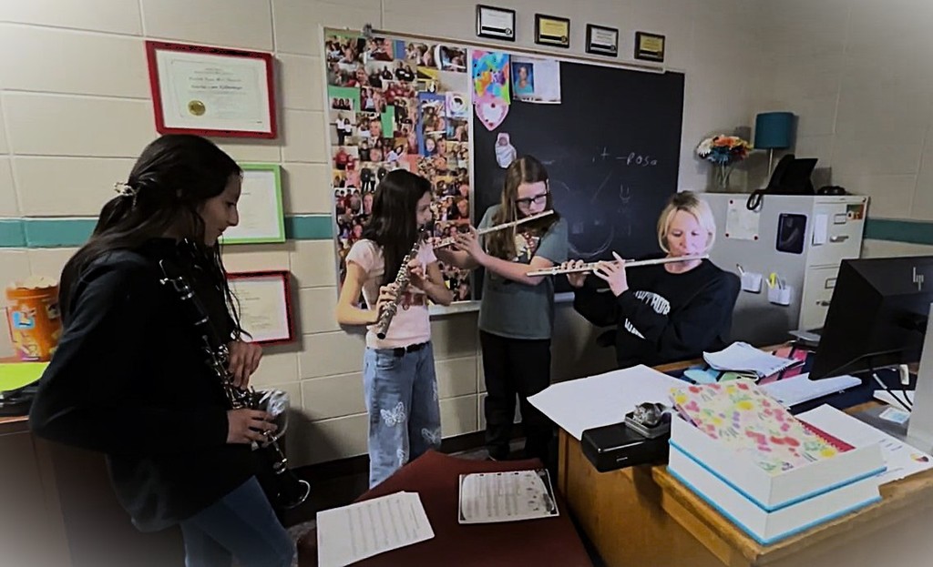 Ms. K. and 5th grade students practice playing the flute during lunch