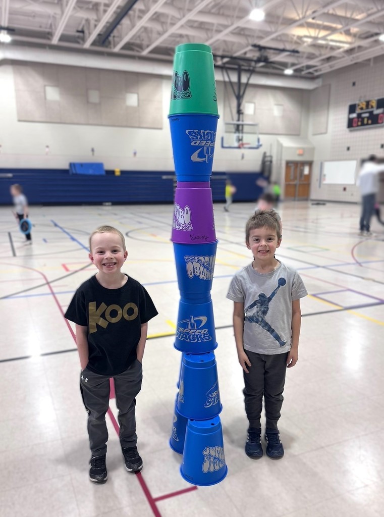 Kindergarten students building towers out of plastic cups. 