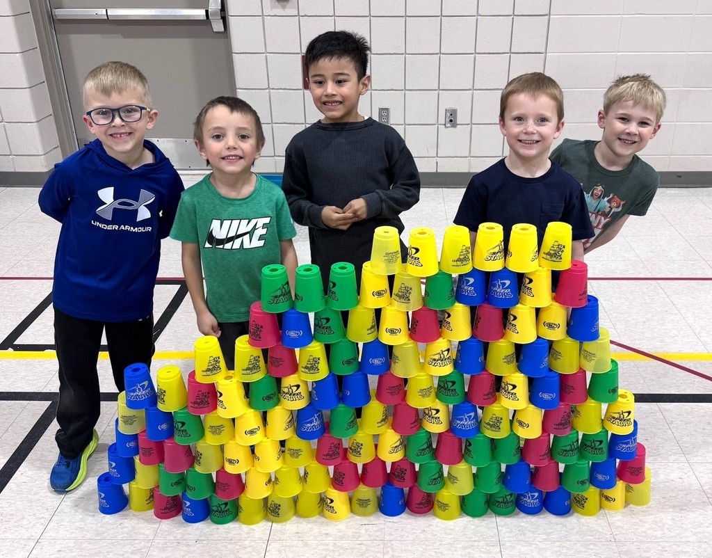 Kindergarten students building towers out of plastic cups. 