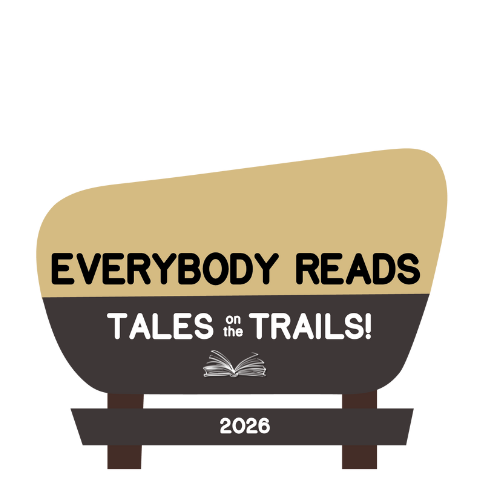 brown and tan park sign with text "everybody reads: tales on the trails"