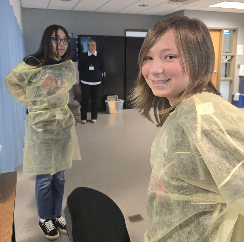 Two students dressed in yellow medical gowns.
