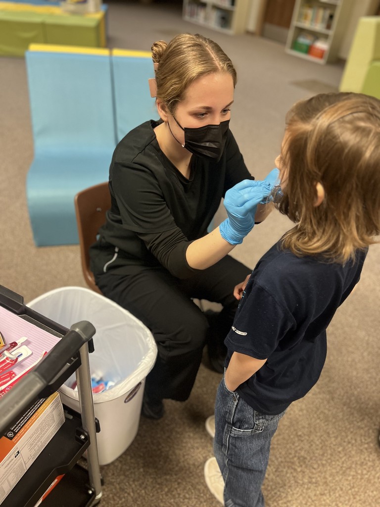 Dental clinic applying varnish to students teeth
