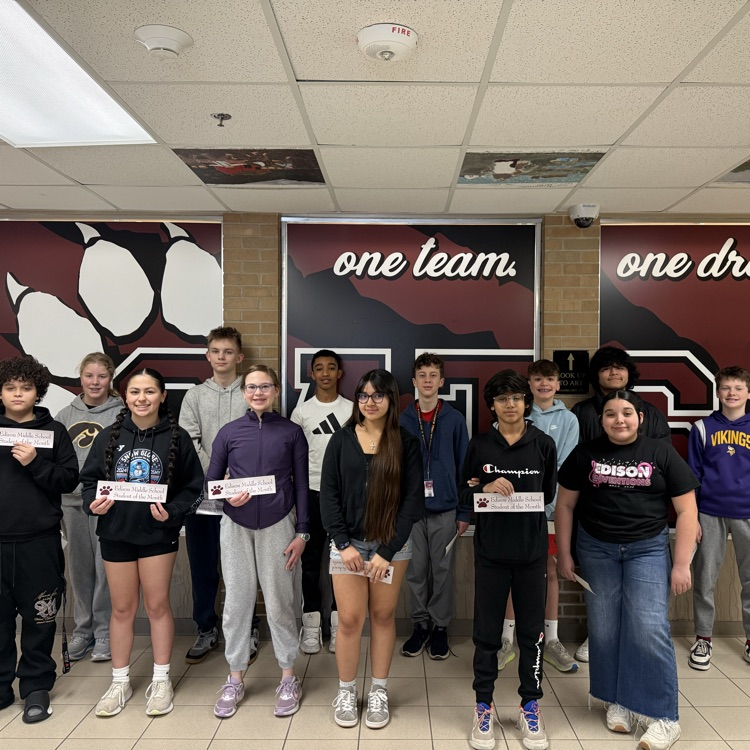 students standing posed in a hallway for a picture with their student of the month certificates 