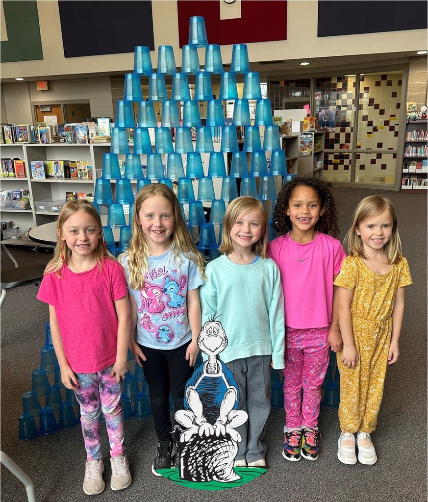 First grade students standing in front of a tower of cups.