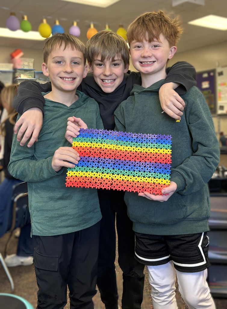 Three boys holding interlocking blocks.