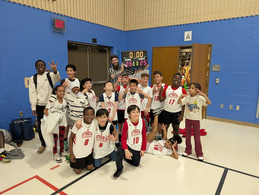 Hayward elementary students in front of the 26-25 scoreboard showing off their win 