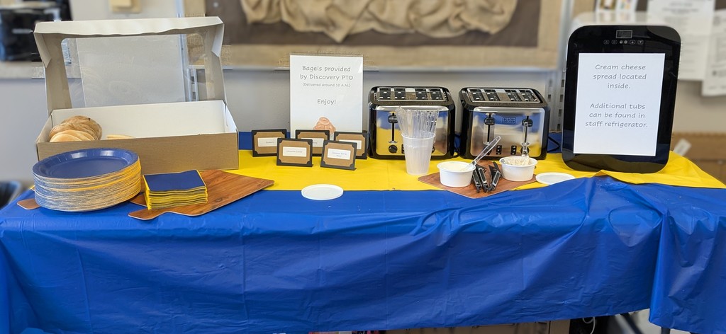 A table setup with bagels and cream cheese.