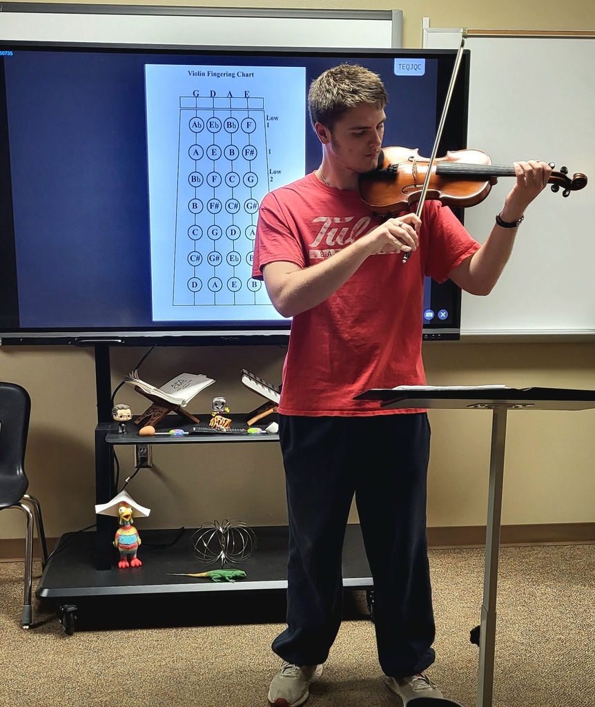 Student posing with his violin for his visual speech