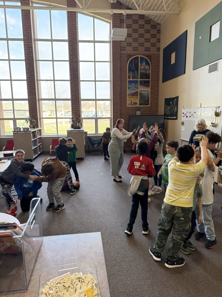 students playing a game in library with Ms. Virginia