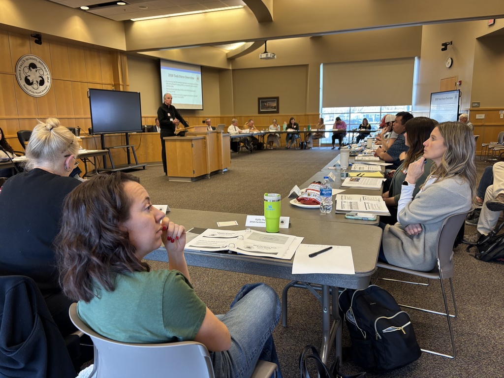 Members of the facilities task force look contemplatively at the screen in front of them that reads "2026 Task Force Overview"