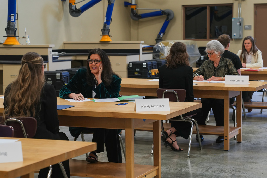 A classroom at CTE Academy is filled with long tables where business representative from the community sit across from Academy of Finance students completing mock interviews for summer internships.