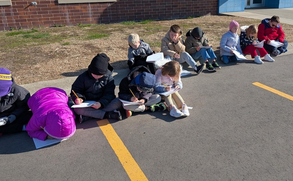 Students looking at the sky and drawing. 