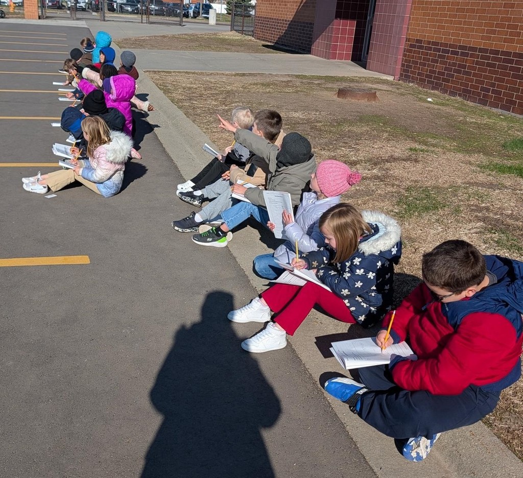 Students looking at the sky and drawing. 