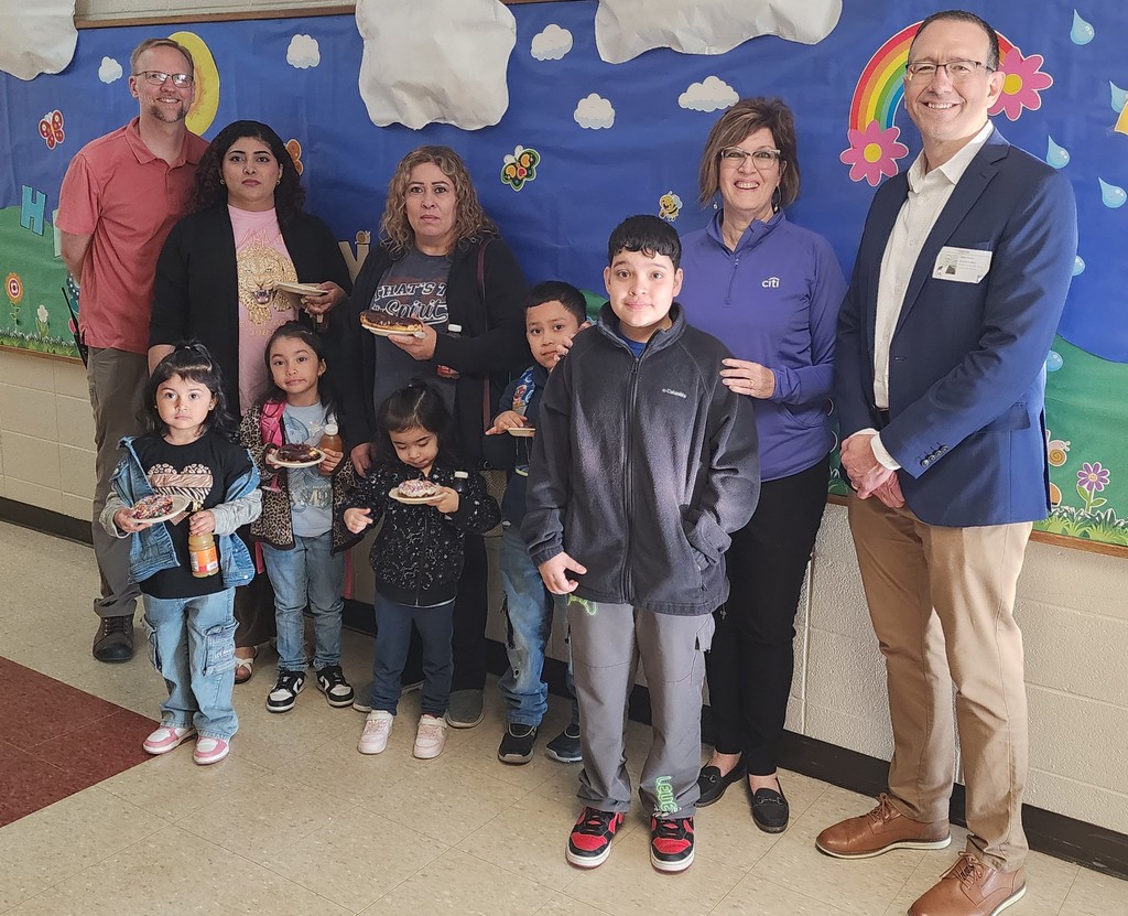 contest winner and family with principal and Citi volunteers