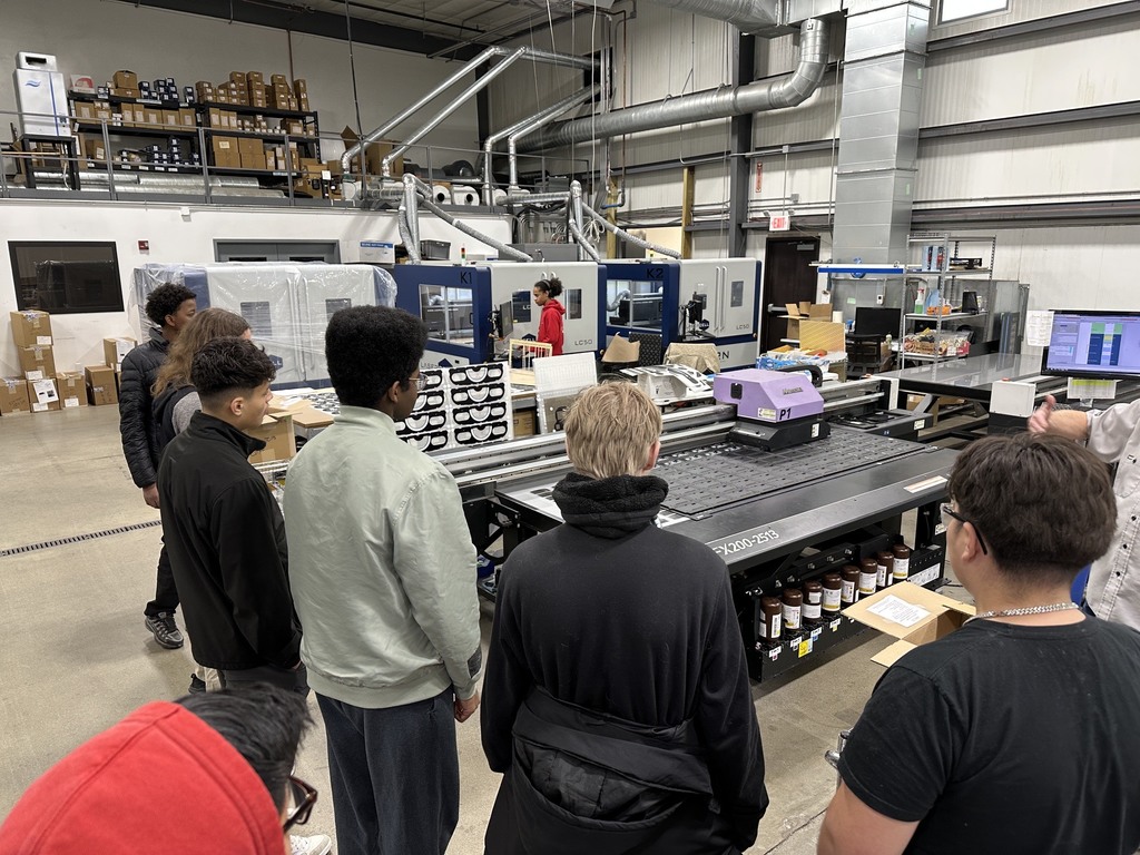 Students looking at the machinery for building vehicle dashboards