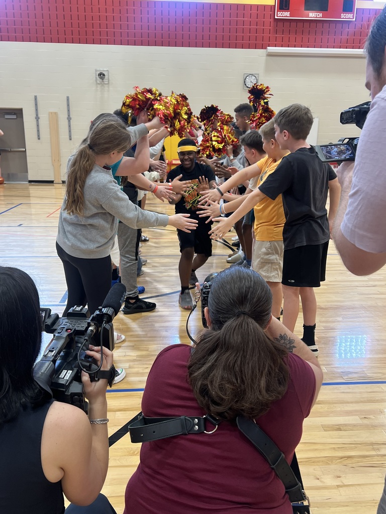 A member of the Ben Reifel Unity team gives high fives to his peers as he runs through the starting line-up tunnel.