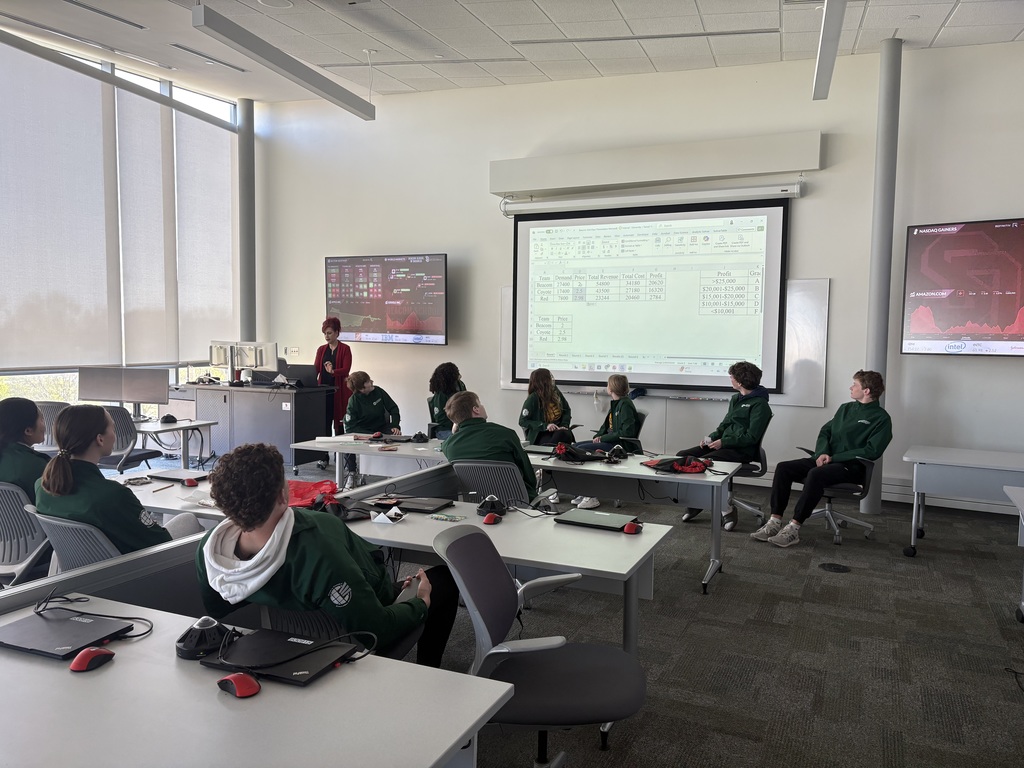 Students in a classroom listening to a guest speaker