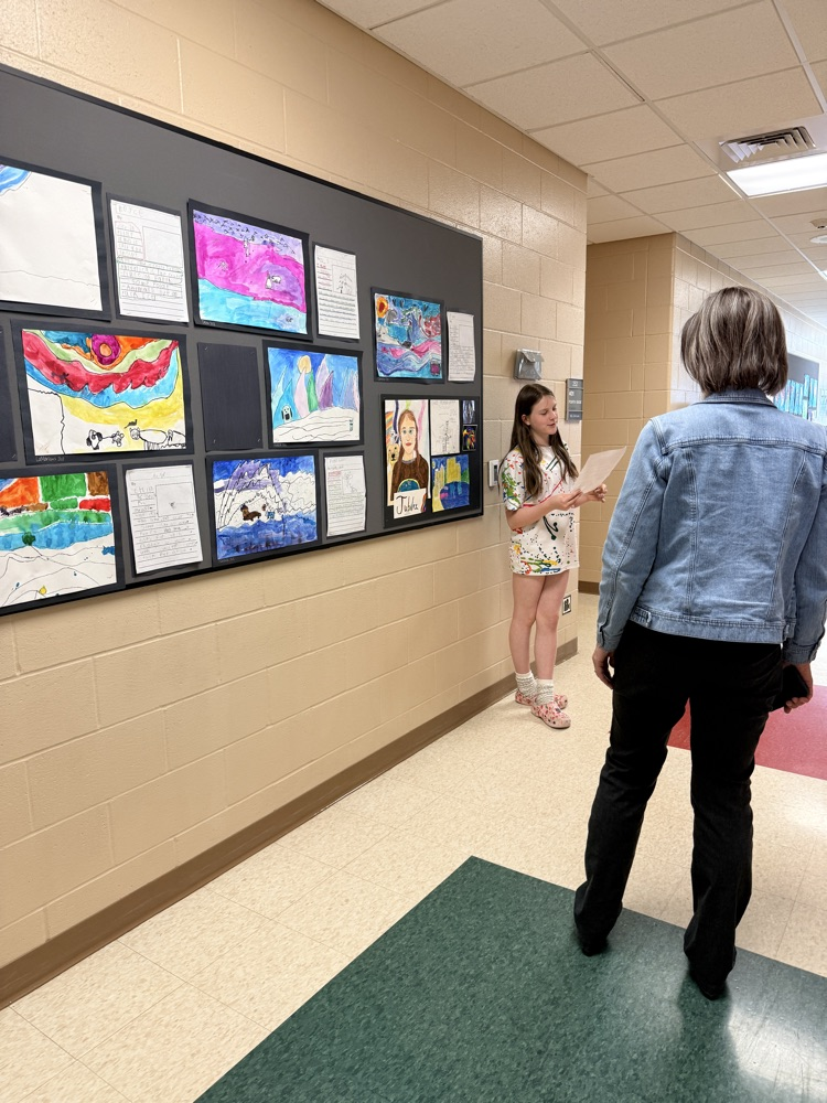student performing a monologue in front of artwork 