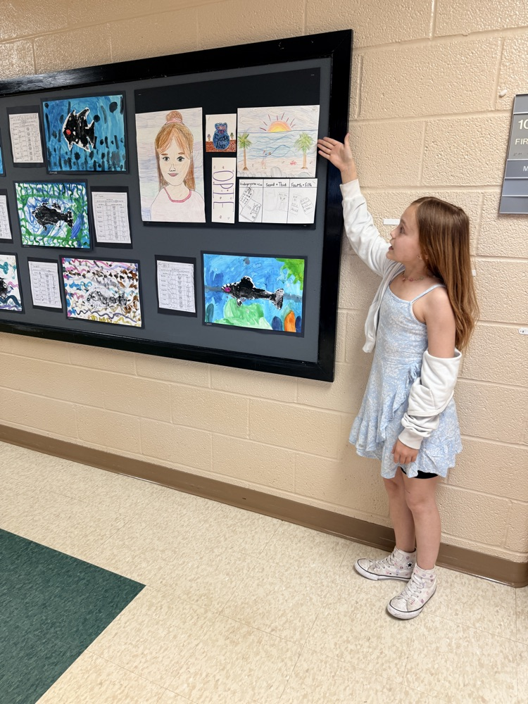 student gesturing to artwork 