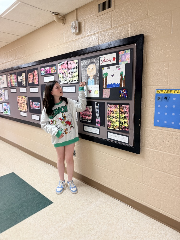 student gesturing to artwork 