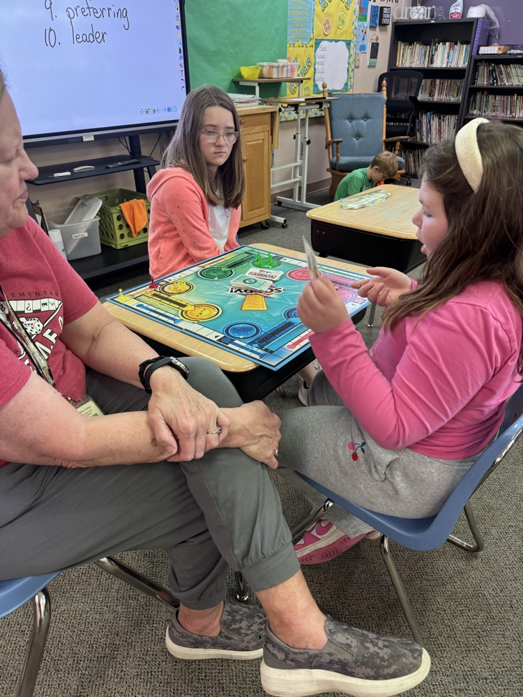 students and an adult helper playing a game