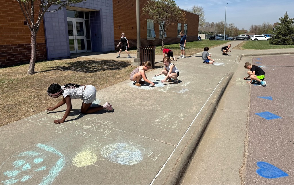 Students drawing with outside chalk. 