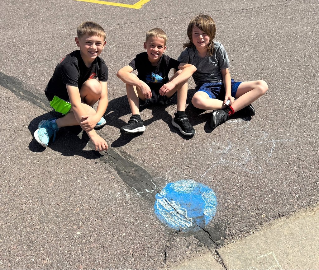 Students drawing with outside chalk. 