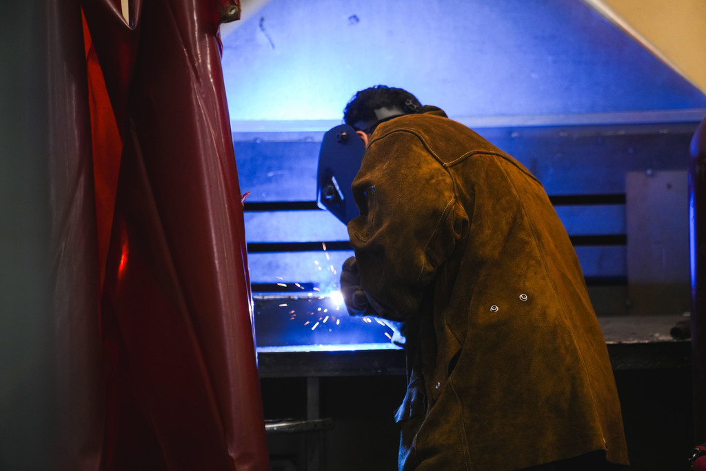 a blue light comes off of a weld that a student is putting together