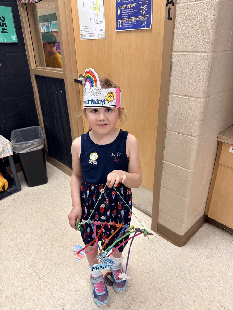 a kindergartner holding a mobile 