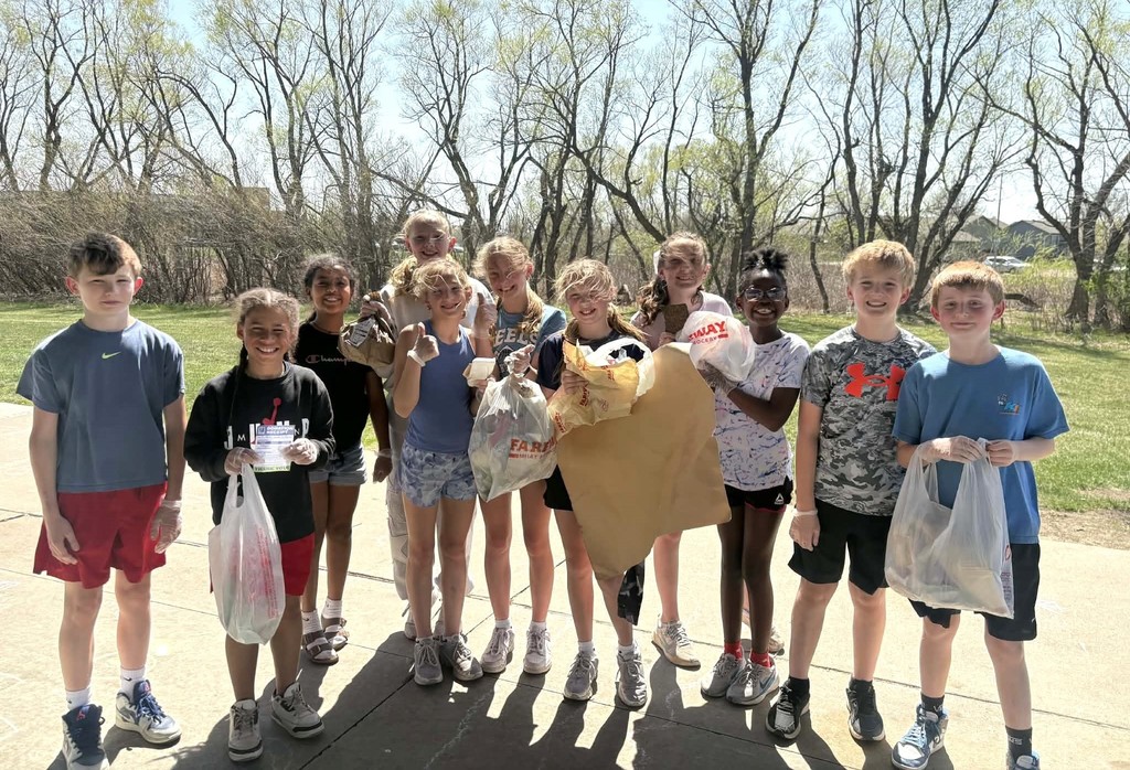 Students holding bags of trash. 