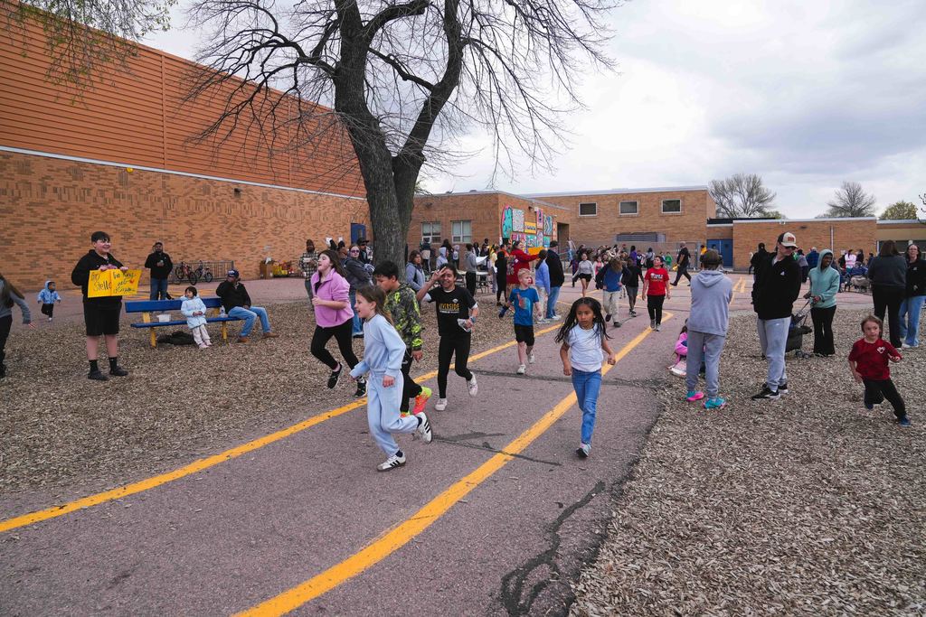 Students run in a race on the school playground