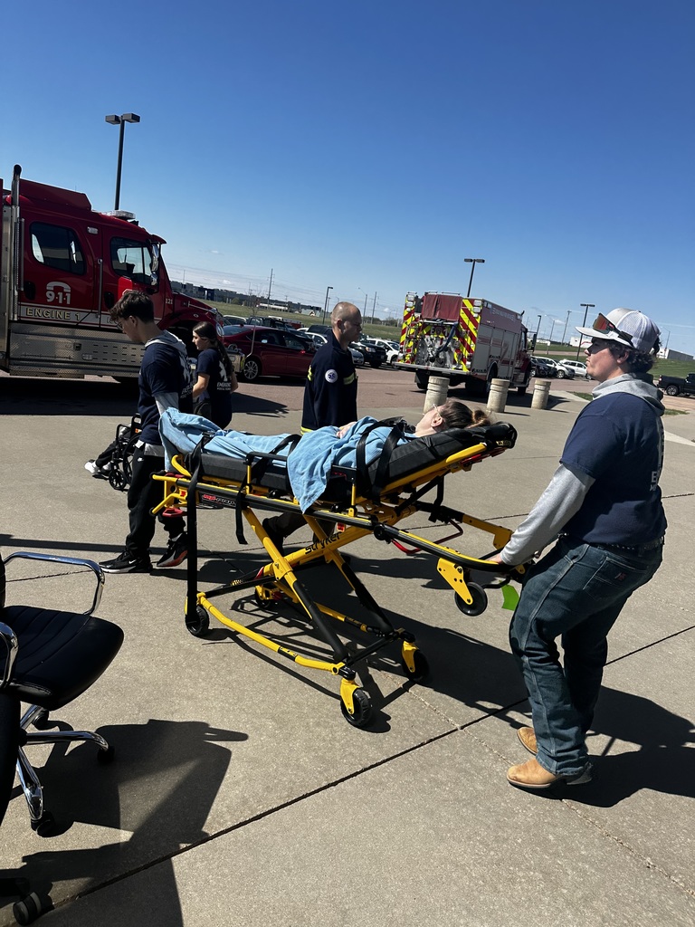 EMT students transporting a patient to the ambulance via a stretcher