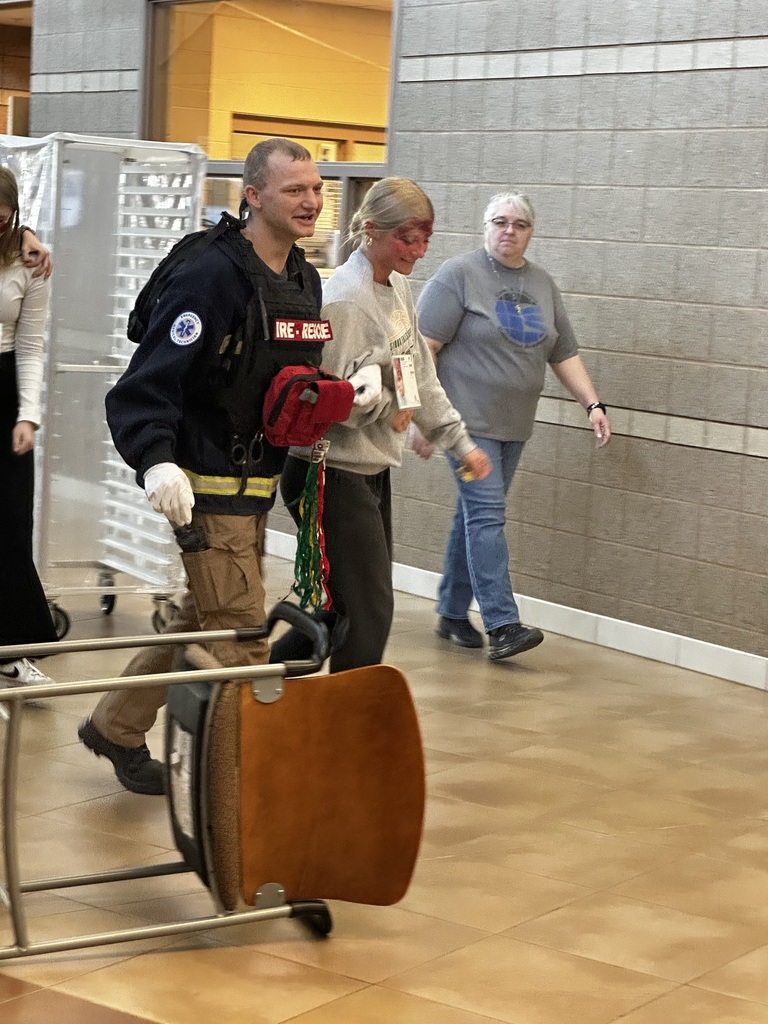 Fire fighter helping a student to the treatment area