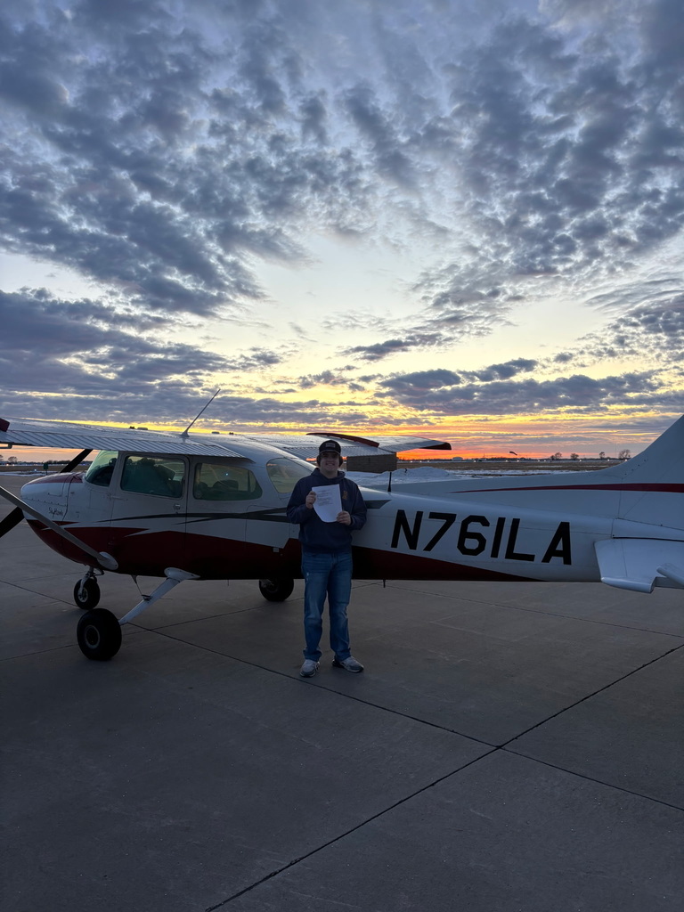 Carson posing in front of a plane