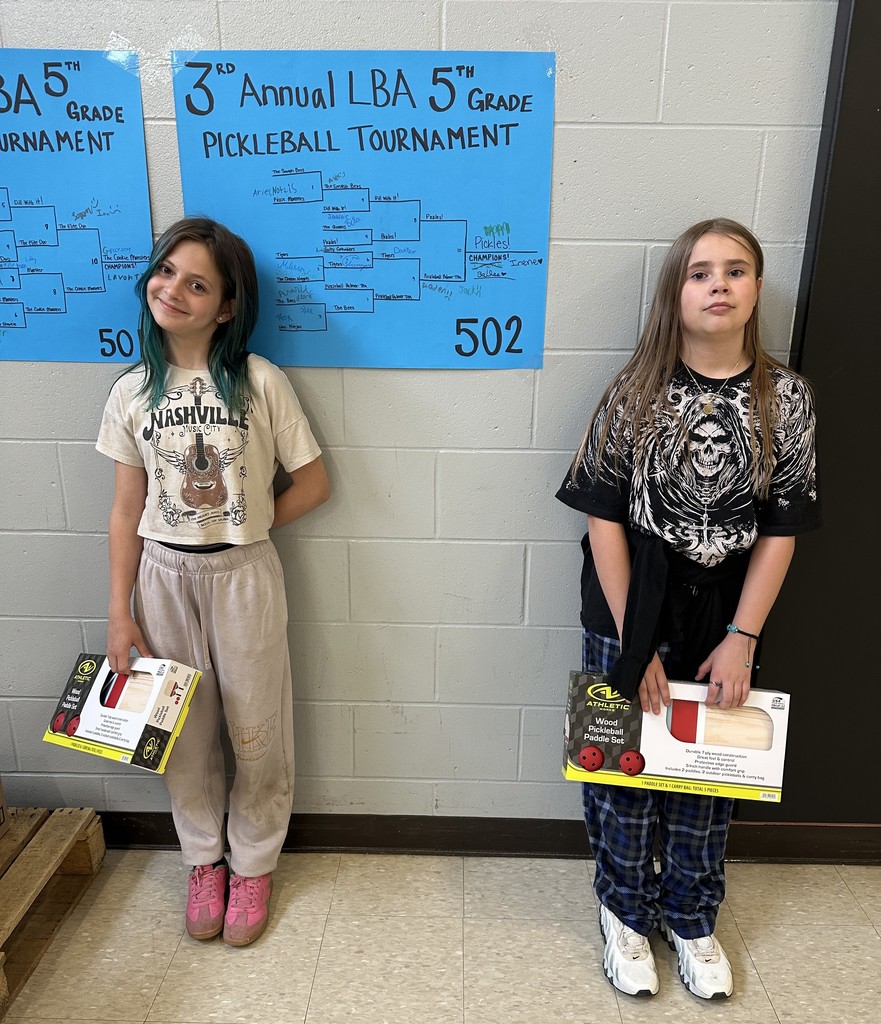 girls standing in front of a tournament bracket
