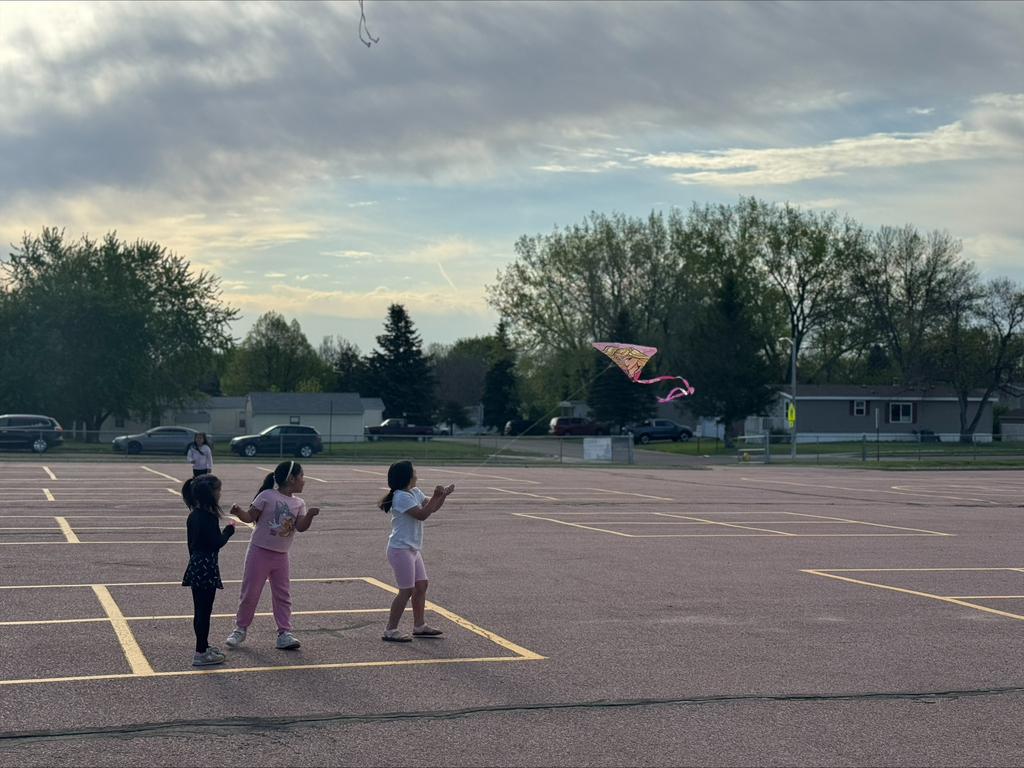 children flying kites on the school playground