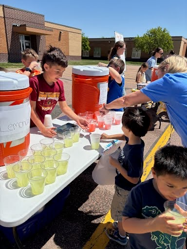 third grade students pouring lemonade for 3-4 year old students