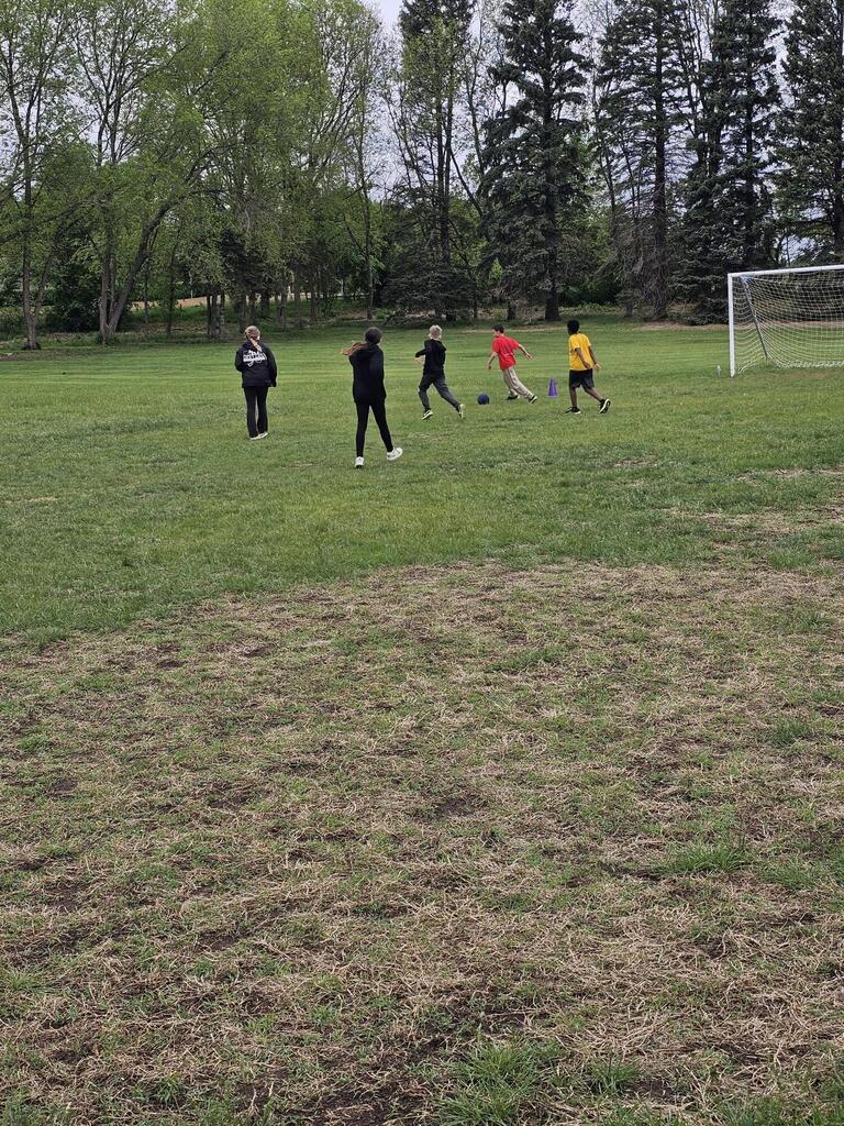 group of 5 boys playing soccer