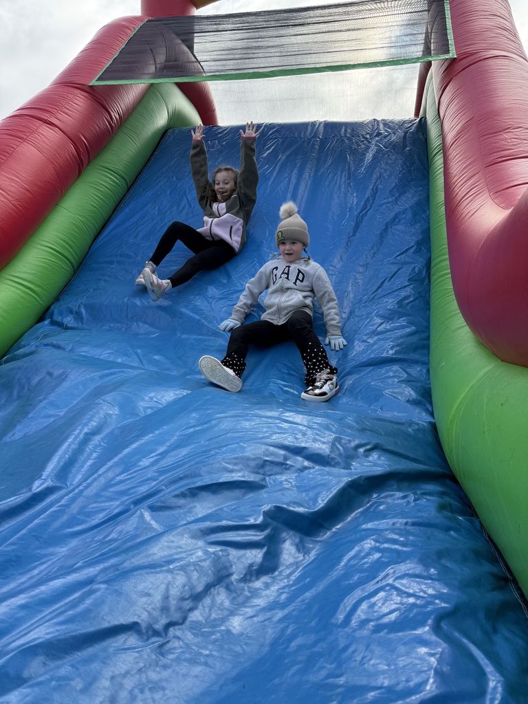 2 girls coming down an inflatible slide
