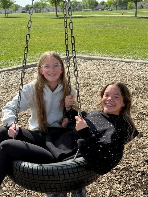 Two students on tire swing.