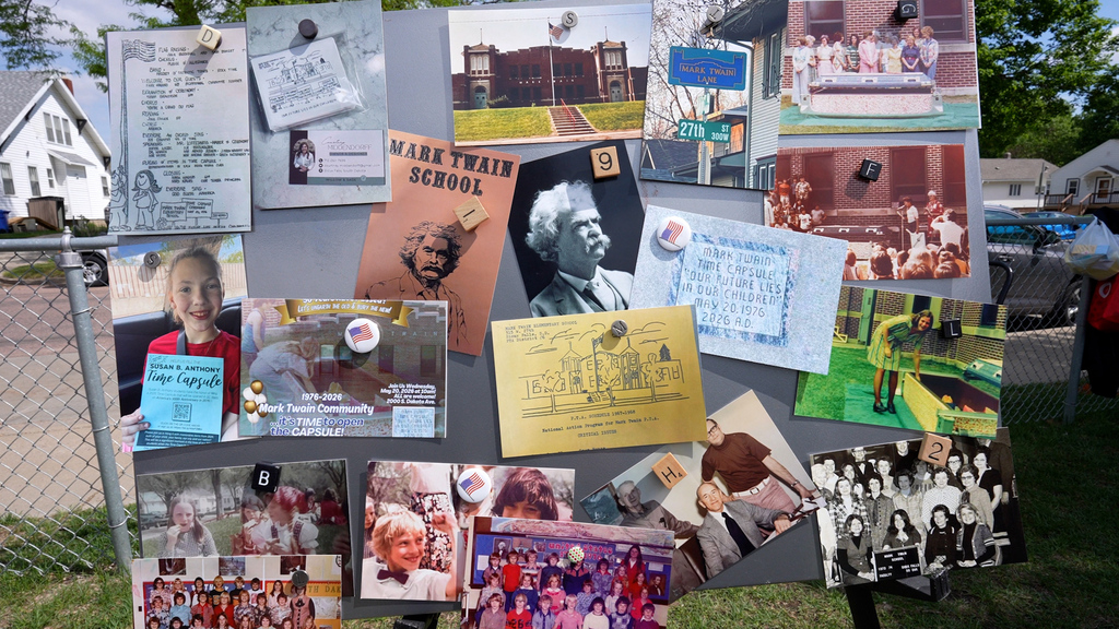 A poster board with postcards of Mark Twain elementary on it. Old school photos and memorabelia are pinned to the board. 