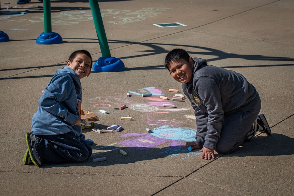 children drawing with sidewalk chalk