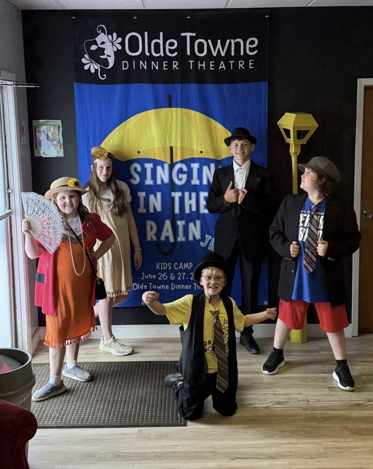 students in front of a backdrop at a theatre 