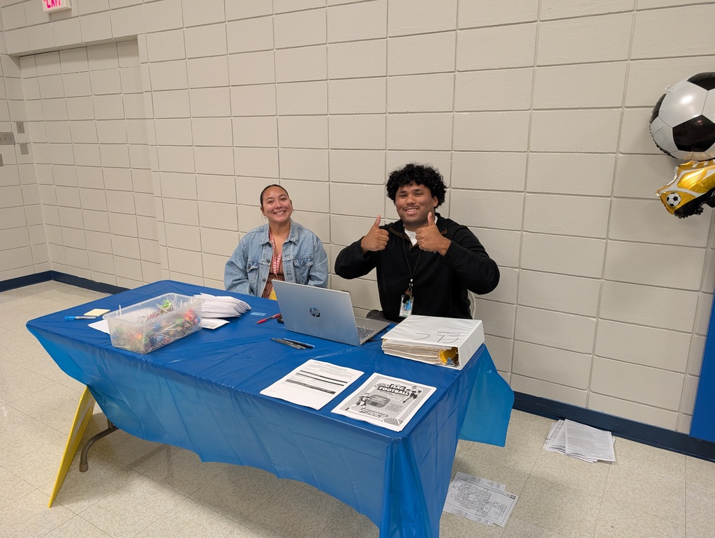 School staff waiting to greet families in the gymnasium