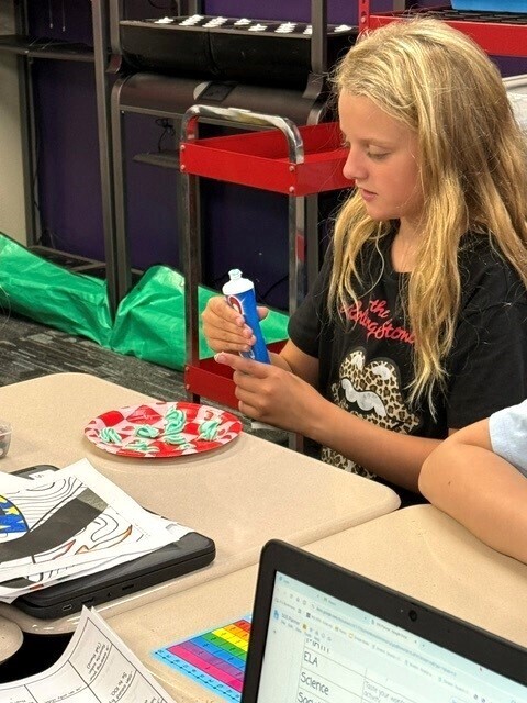 Students putting toothpaste on a plate. 