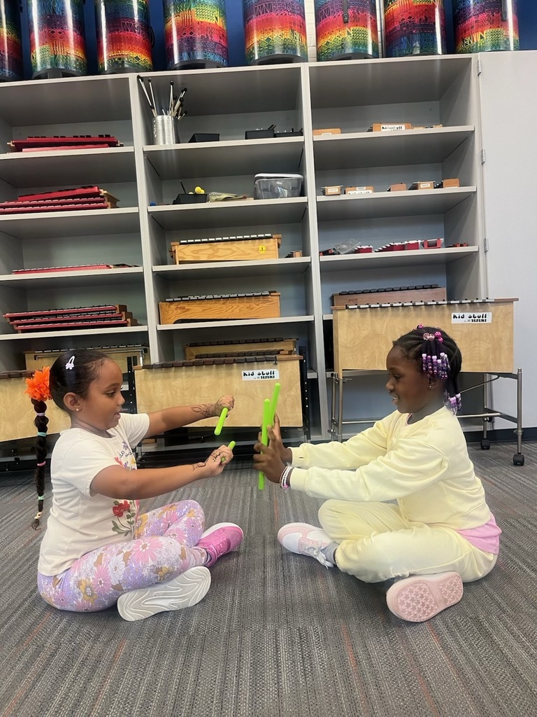 Two girls using rhythm sticks